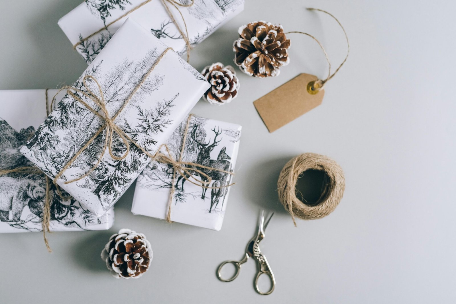 Beautifully wrapped Christmas presents with pine cones and twine in a minimalist style. Perfect for holiday inspiration.